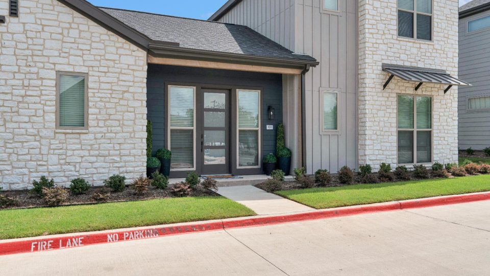 the front of a home with a driveway and grass at The parcHAUS at Firewheel Parkway