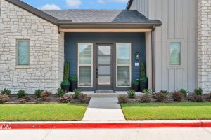 a home with a front door and a green lawn at The parcHAUS at Firewheel Parkway