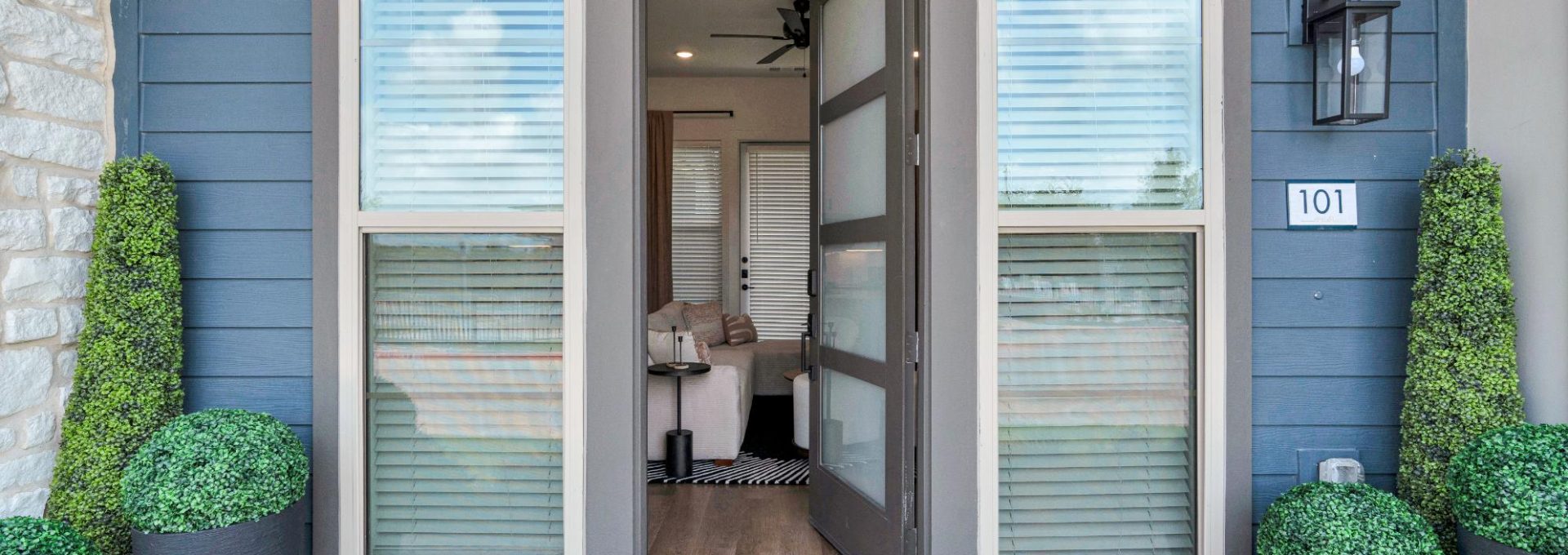 a front door with a potted plant and a rug at The parcHAUS at Firewheel Parkway